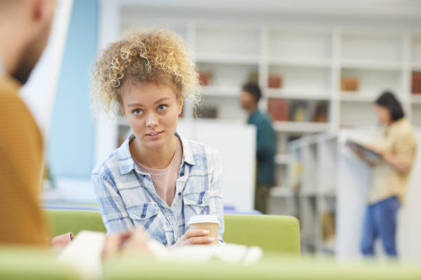istock Female Student Talking to Friend in Library 1202384455