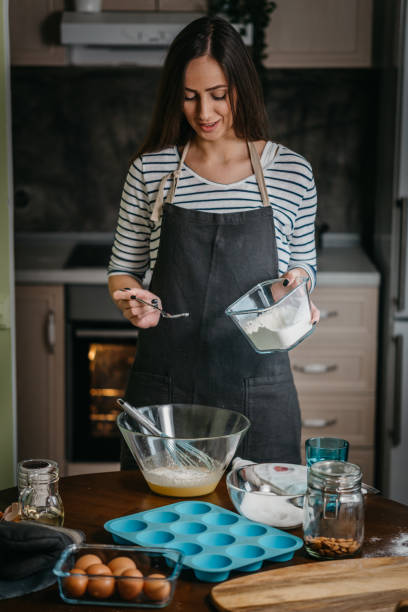 istock Cheerful woman making cupcakes 1202384645