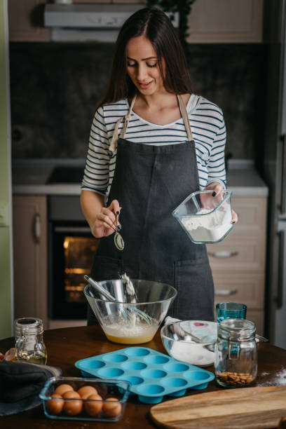 istock Cheerful woman making cupcakes 1202384659