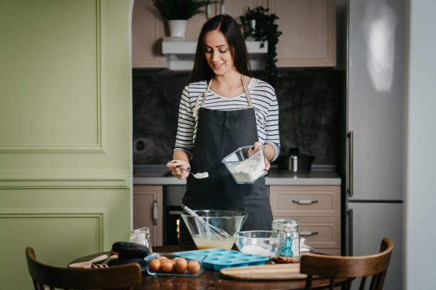istock Cheerful woman making cupcakes 1202384666