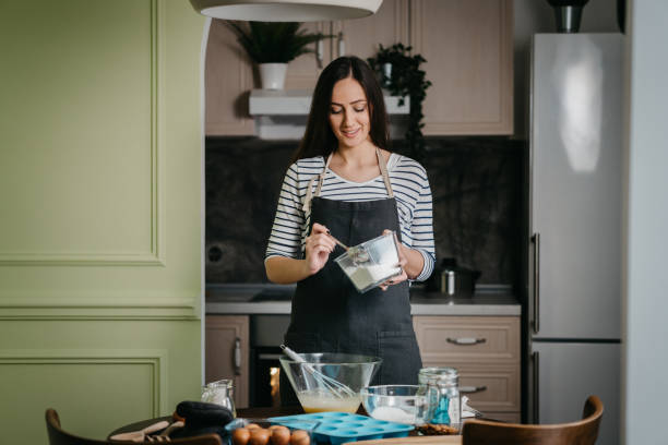istock Cheerful woman making cupcakes 1202384688