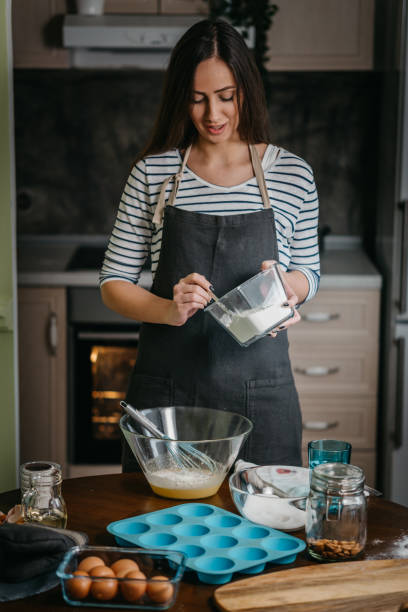 istock Cheerful woman making cupcakes 1202384709