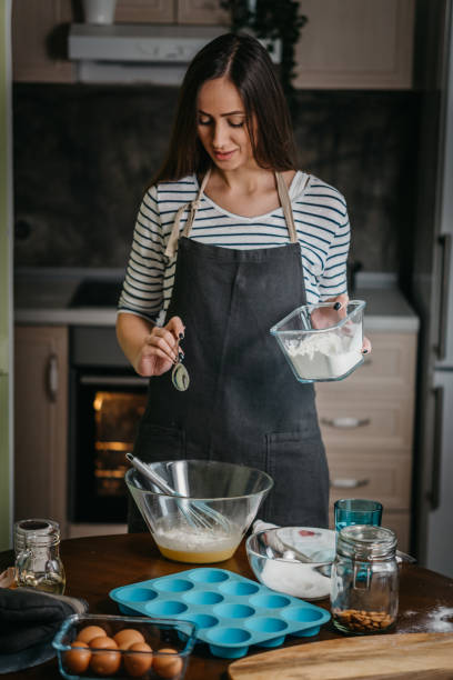 istock Cheerful woman making cupcakes 1202384751