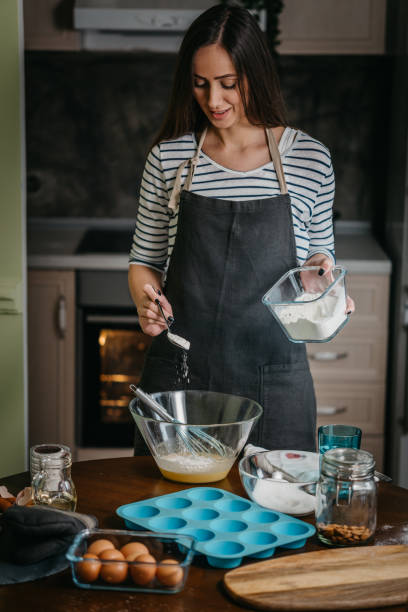 istock Cheerful woman making cupcakes 1202384786