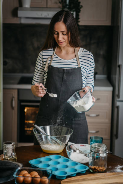 istock Cheerful woman making cupcakes 1202384857