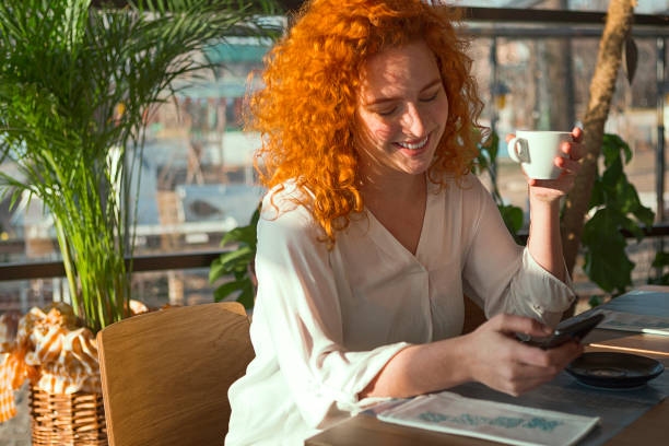 istock Young woman using smart phone in cafe 1202384959