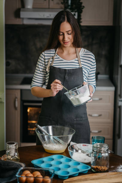 istock Cheerful woman making cupcakes 1202385480