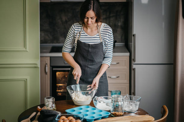 istock Cheerful woman making cupcakes 1202385506