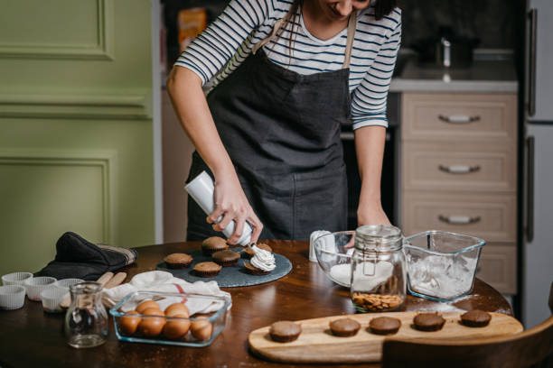 istock Woman Making Creamy Top On Cupcakes 1202385524