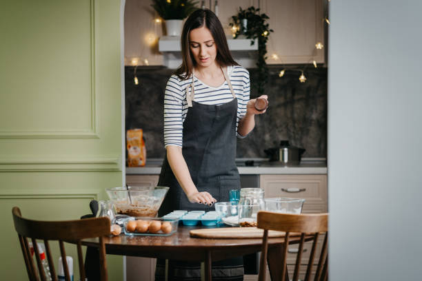 istock Cheerful woman making cupcakes 1202385646