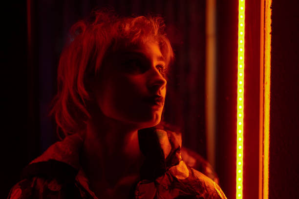 serious young woman in neon light - soft lighting imagens e fotografias de stock