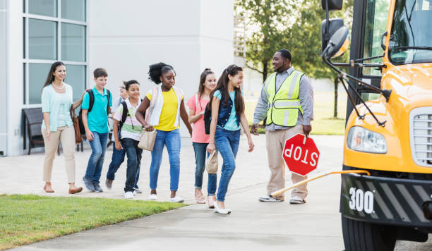 istock Students and teacher boarding school bus 1202386993