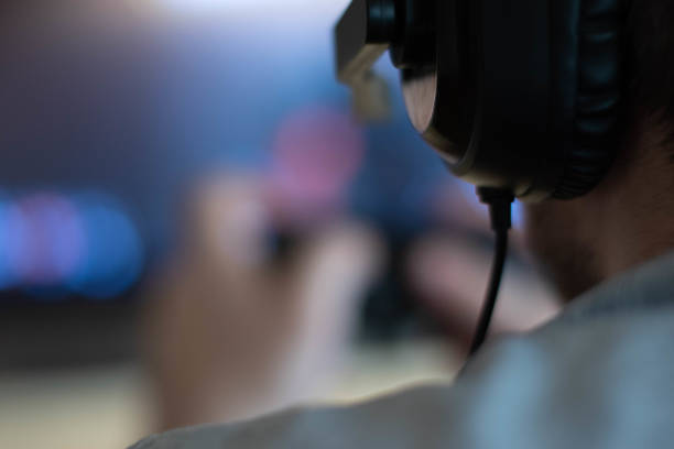 istock Close-up headphones while men playing video games late at night 1202387087