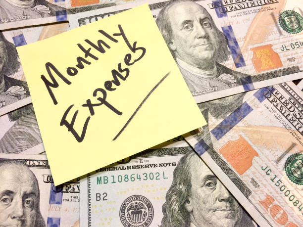 American cash money and yellow post it note with text Monthly expenses American cash money and yellow post it note with text Monthly expenses in black color aerial view philadelphia federal reserve stock pictures, royalty-free photos & images