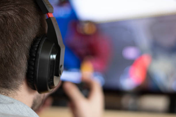 istock Man playing video game in dark room 1202387766