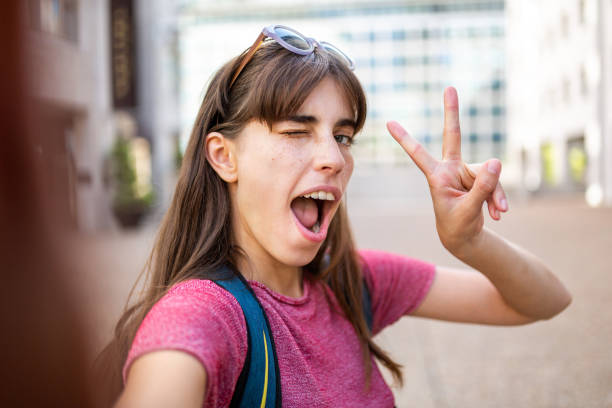 istock fun smiling young woman taking selfie with cellphone 1202391586
