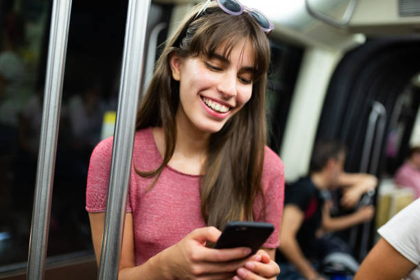 istock happy young woman looking at cellphone in train 1202391661