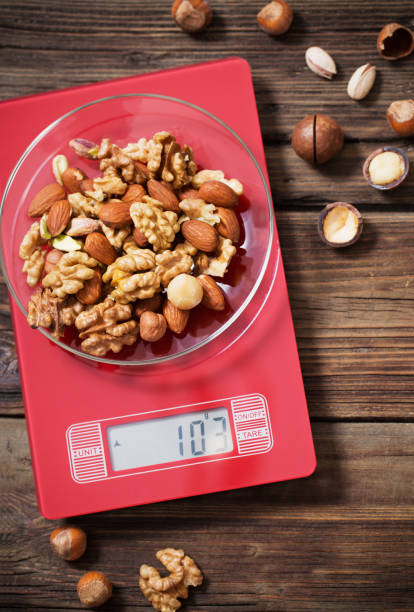 istock mix of different nuts on  kitchen scale on old wooden background 1202391727