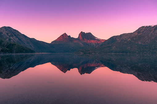 Picturesque nature background with Cradle Mountain and lake at sunrise with colorful sky and water reflection. Sunrise mountain background. HDR photo