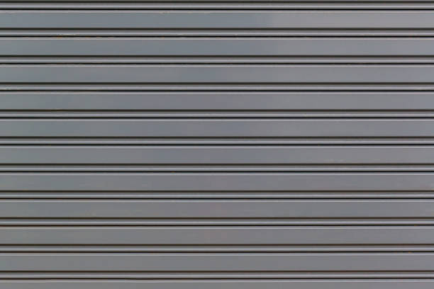 istock Metallic roll up door. Old Steel rolling shutter background. Metal security shutters protecting a small shop. 1202393280