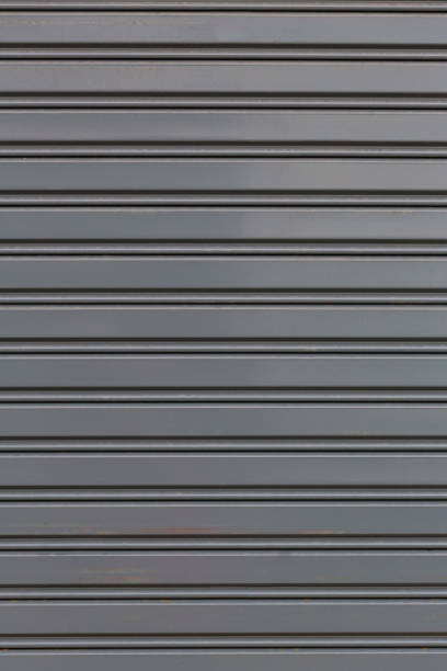 istock Metallic roll up door. Old Steel rolling shutter background. Metal security shutters protecting a small shop. 1202393301