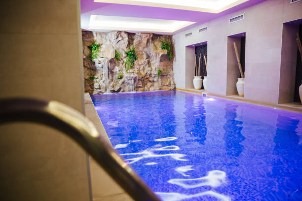 istock Indoors pool with colorful lights at spa center 1202397069