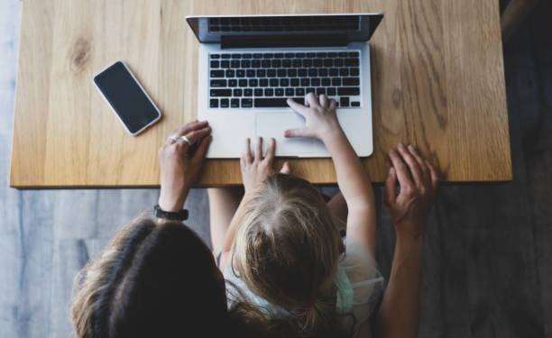 istock A little girl using a laptop with her mother 1202397073