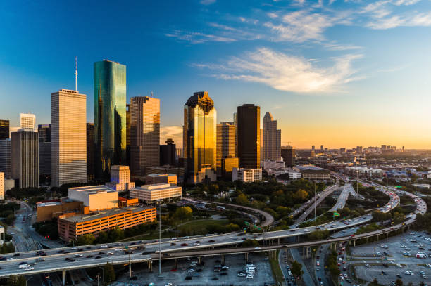 Houston Downtown Aerial at Sunset, Angled View with Highway Downtown Houston skyline aerial at sunset with a highway in the foreground, angled view with the Texas Medical Center in the far distance texas stock pictures, royalty-free photos & images