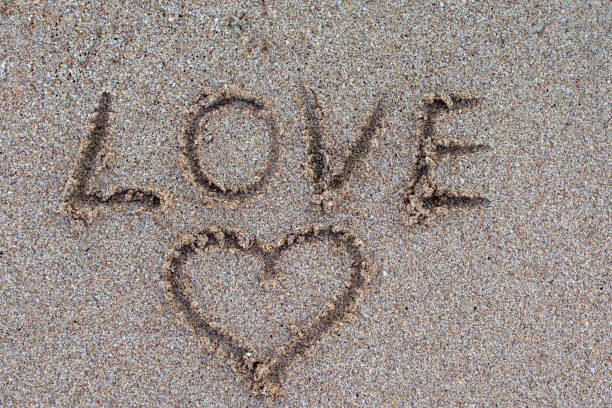 istock love message written in sand. 1202398550
