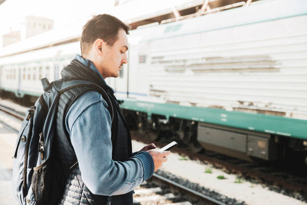 istock Tourist Looking at His Mobile Phone at Railway 1202399494