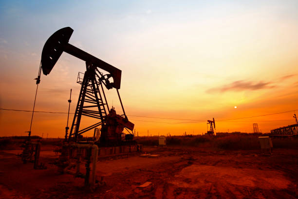 hora do pôr do sol da bomba de petróleo, equipamento da indústria petrolífera - oil pumping unit at sunset time - fotografias e filmes do acervo