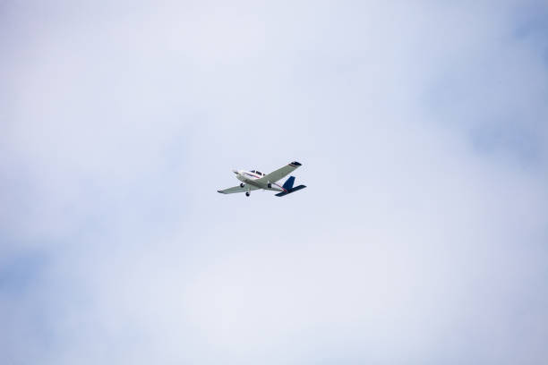 istock Small cessna 172 airplane soars through blue sky 1202407929