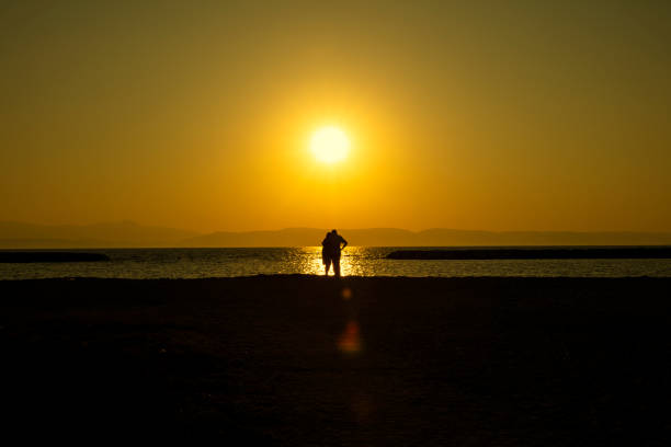 Kincardin, Canada – July 03, 2018: Kincardine, Ontario / Canada - July 3, 2018 - Couple taking picture of beautiful sunset over Lake Huron at Station Beach pier