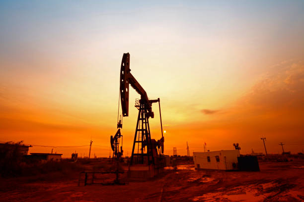 hora do pôr do sol da bomba de petróleo, equipamento da indústria petrolífera - oil pumping unit at sunset time - fotografias e filmes do acervo
