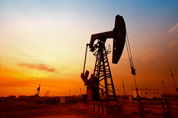hora do pôr do sol da bomba de petróleo, equipamento da indústria petrolífera - oil pumping unit at sunset time - fotografias e filmes do acervo