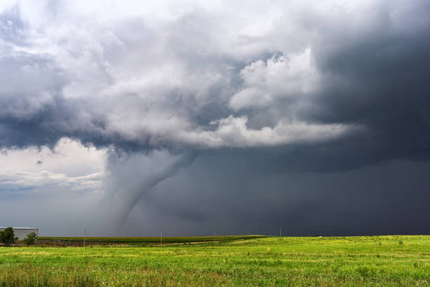 Tornado beneath a supercell thunderstorm Tornado and dark storm clouds beneath a supercell thunderstorm over a field in Colorado. natural disaster photos stock pictures, royalty-free photos & images