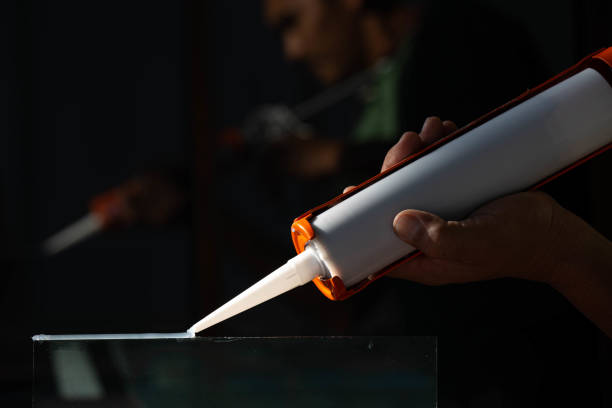 istock Craftsmen are using silicone adhesives for general and industrial applications. 1202413172