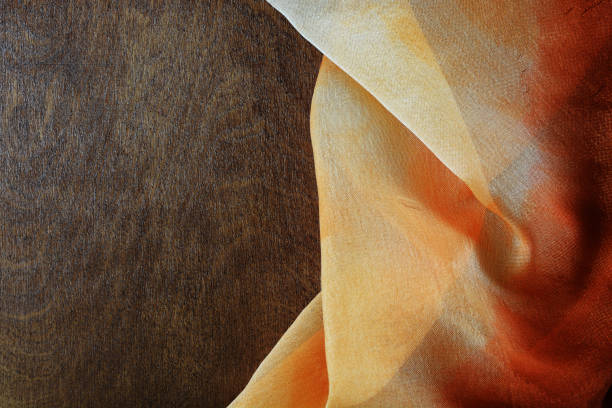 istock Multi-coloured silk fabric on a background of dark wood 1202414939