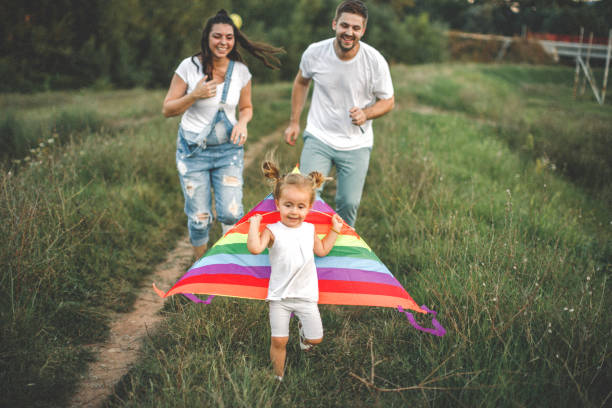 istock Parents playing with girl in nature park3 1202414943