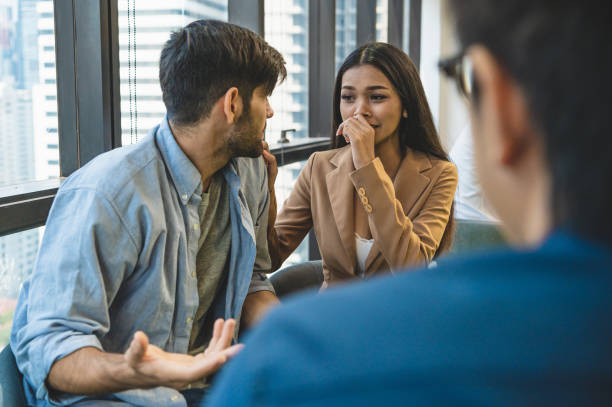 psicoterapeuta che indaga sui sintomi che si verificano all'interno della mente da un paio di pazienti con problemi di salute mentale. psicoterapia di gruppo per il supporto e aiutare l'uomo preoccupato a cambiare mentalità negativa - violence married therapy solution foto e immagini stock