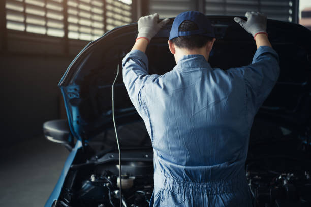 Car mechanic opening car hood for internal checking to maintenance vehicle by customer claim order in auto repair shop garage. Engine repair service. People occupation and job. Automobile technician mecánico de coche de apertura de la campana del coche para la comprobación interna del vehículo de mantenimiento por pedido de reclamación del cliente en el garaje del taller de reparación de automóviles. servicio de reparación del motor. ocupación