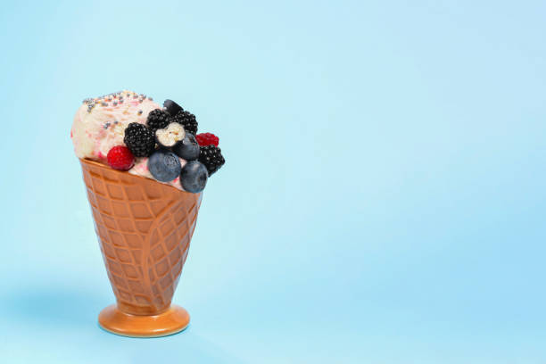 istock Ice cream with blueberries, blackberries and raspberries on a blue background.  Copy space. 1202419978