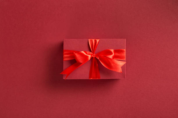 istock Valentine's day or mother's day concept. Red gift box with bow on red background top view 1202420604