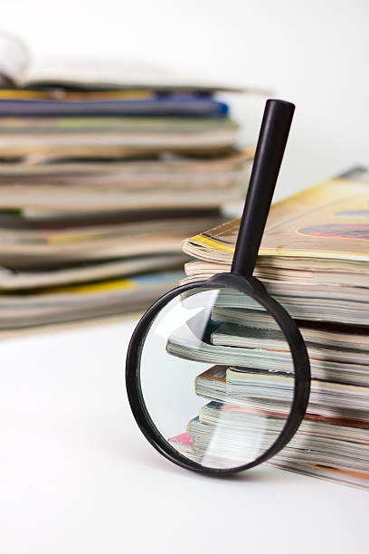 istock Magnifying lens on the stack of magazines background 120242481