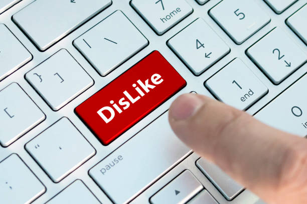 istock A dislike on keyboard button. A male finger presses a color button on a gray silver keyboard of a modern laptop. Button with inscription close up.s. 1202427593