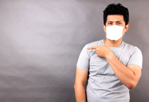 istock Asian man wearing a mask is sick isolated on gray background in studio. 1202432187