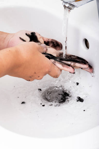 Women's hands washing the sticky black mask off them stock photo