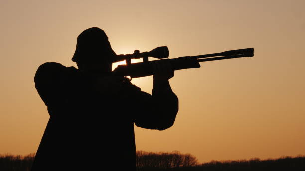 istock A man with a rifle takes aim at sunset, silhouette 1202433455