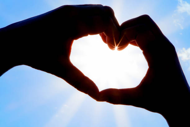 istock Hands forming a heart shape over the sun 1202434292