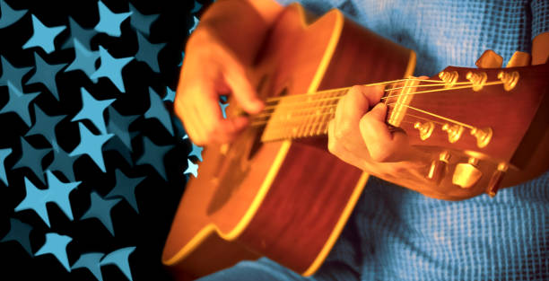 istock Man playing an acoustic guitar during a concert (beautiful bokeh) 1202436812